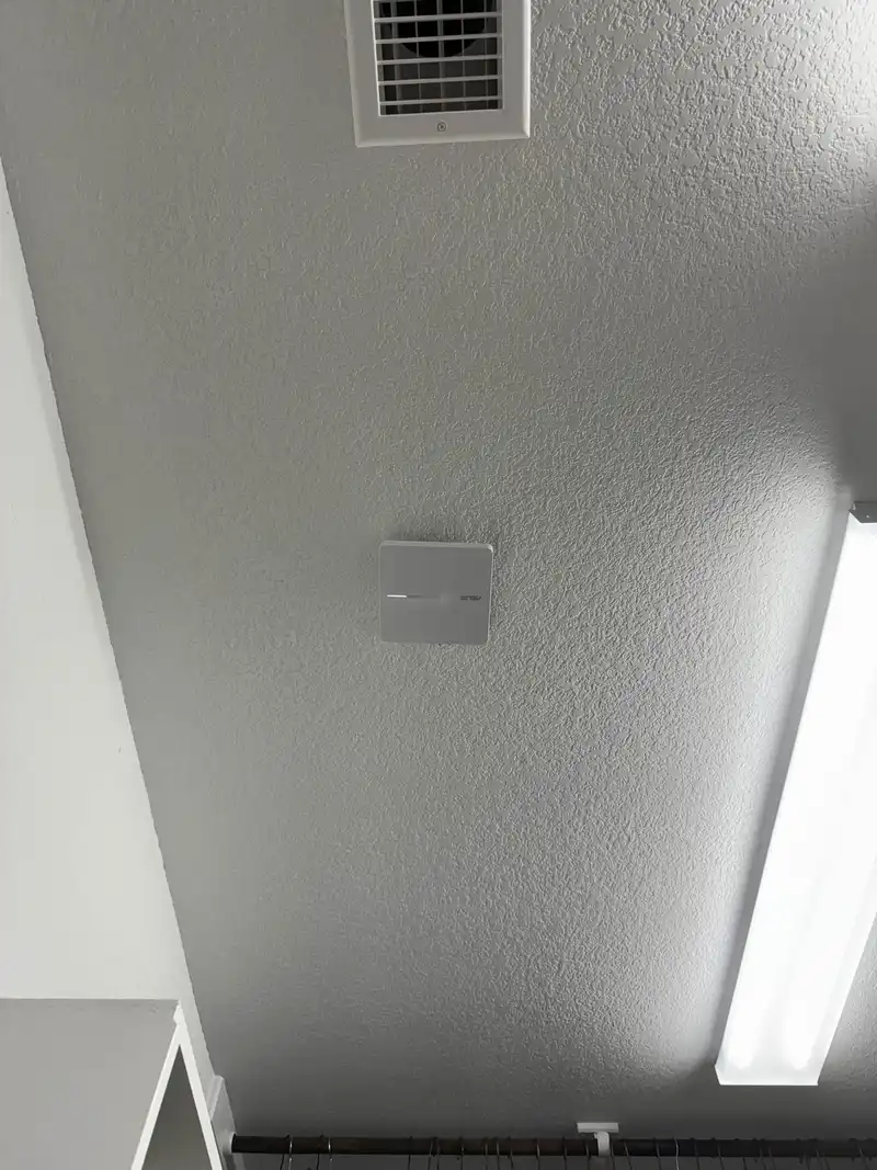 Ceiling-mounted WiFi access point installed for full building wireless coverage