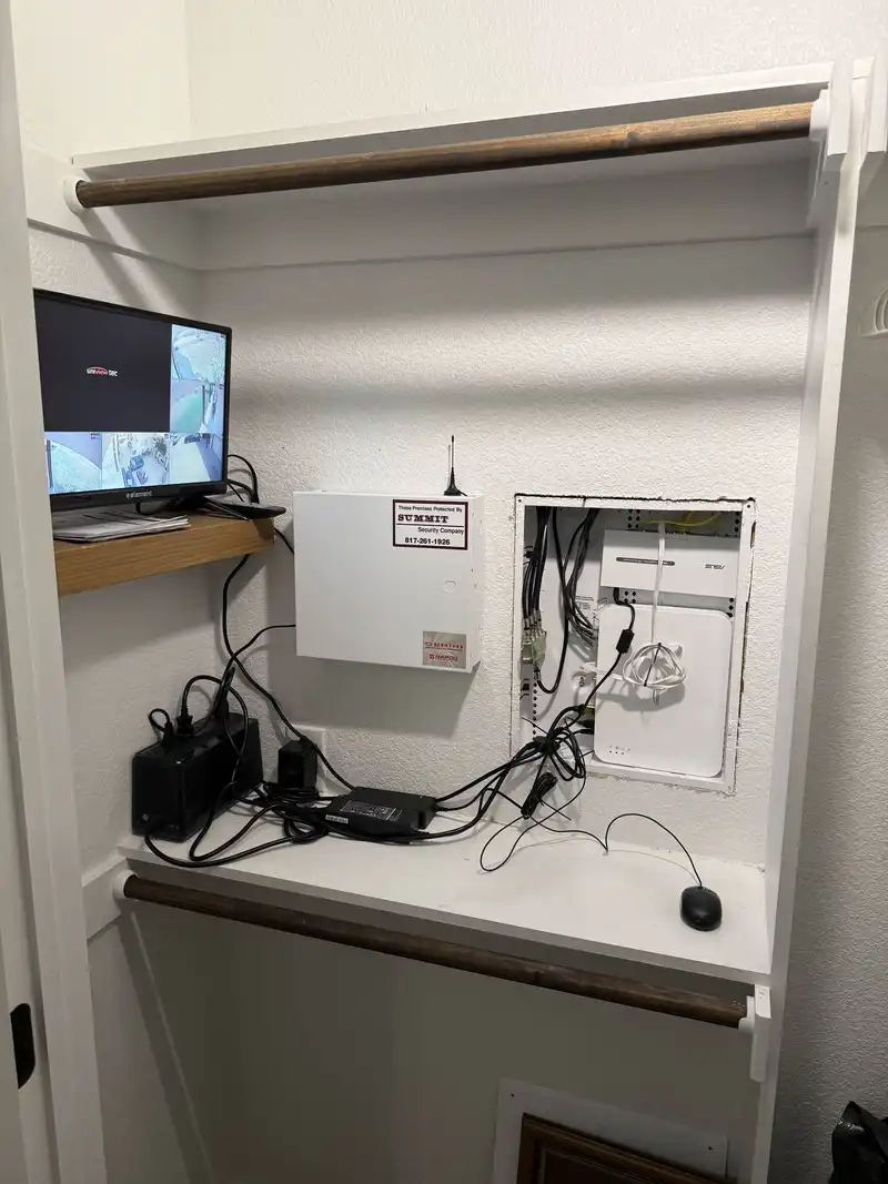 Network closet after professional cleanup with organized cabling and security cameras online