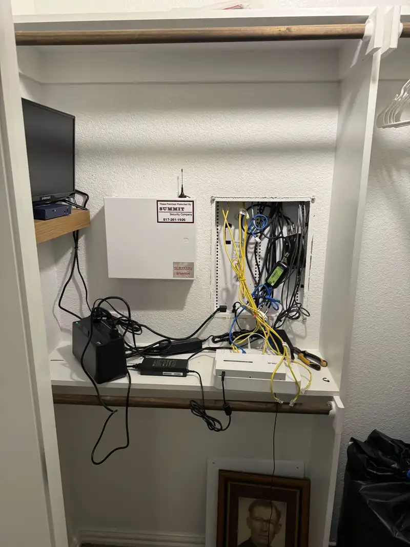 Network closet before cleanup showing tangled cables and disorganized equipment