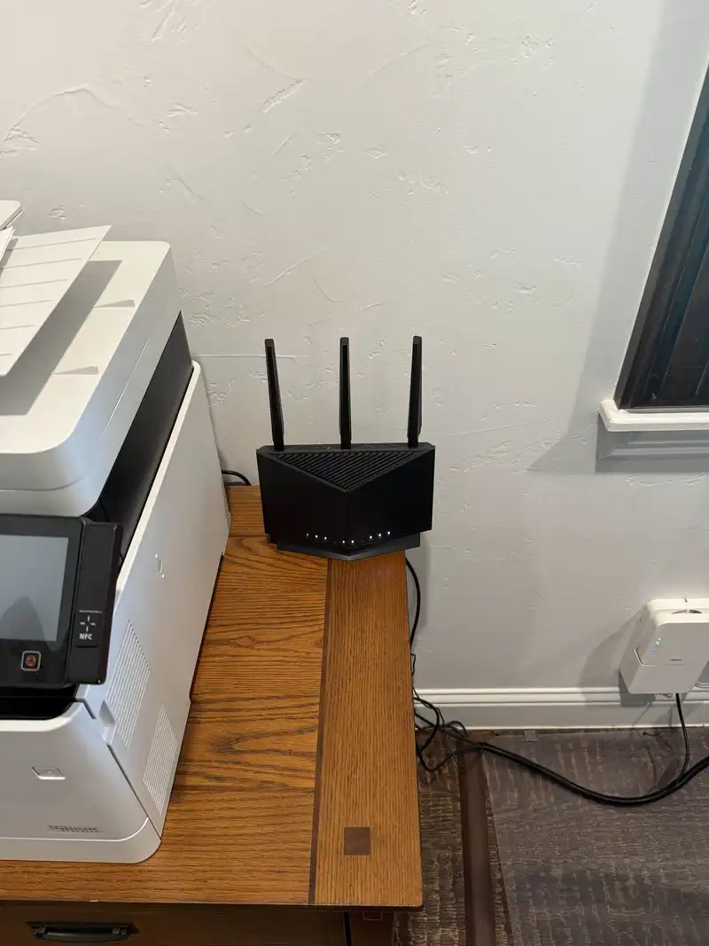 Business WiFi router installation with ASUS tri-band router deployed on desk