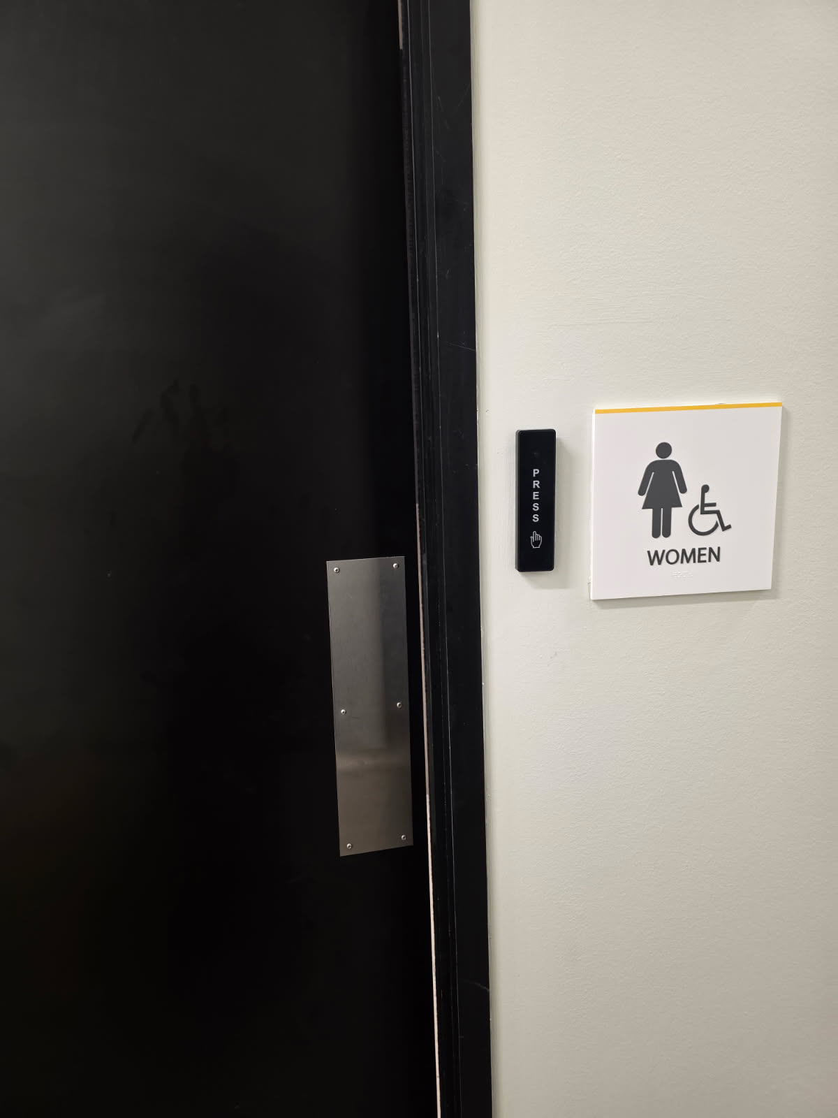 Card reader and press-to-exit button installed next to women's restroom door in Dallas office